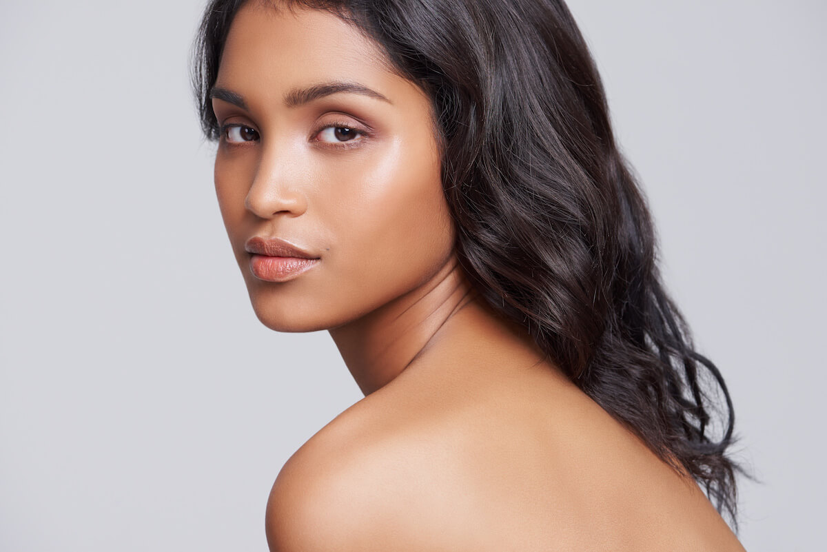 woman looking over bare shoulder