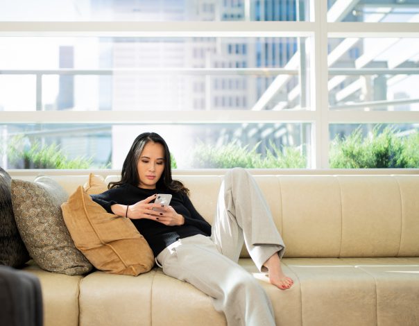 Woman lounging on a couch on her phone