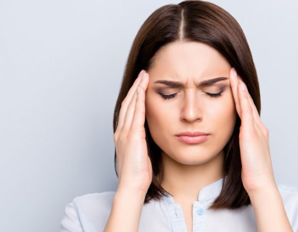 Woman holding her head with a migraine