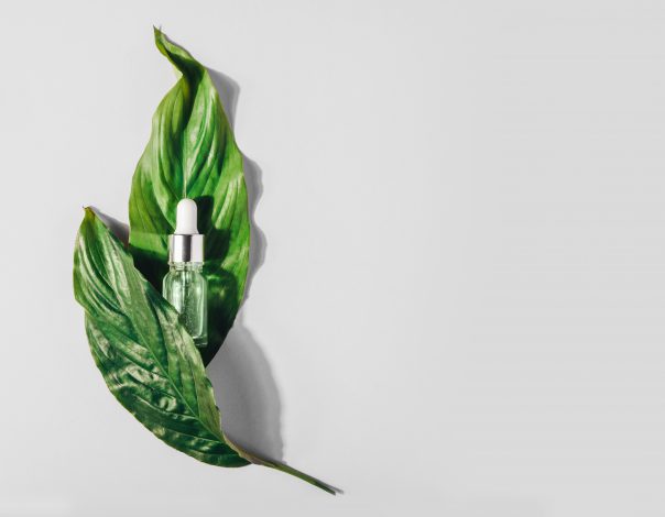 Bottle with natural serum with vitamins on background.