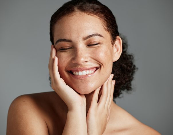 Face, beauty and satisfaction with a model black woman in studio on a gray background to promote natural skincare. Facial, wellness and makeup with an attractive young female happy with cosmetics