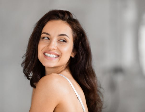 Smiling woman looking back over shoulder, copy space